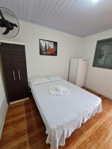een slaapkamer met een groot wit bed in een kamer bij Residencial Primo in Capão da Canoa