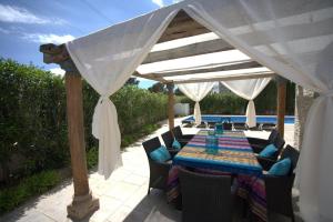 La Villa La Vie في بولوب: طاولة تحت جناح مع كراسي وطاولة زرقاء