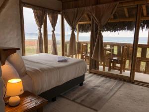 a bedroom with a bed and a view of the ocean at Cabalonga EcoAdventure in Puerto Cayo