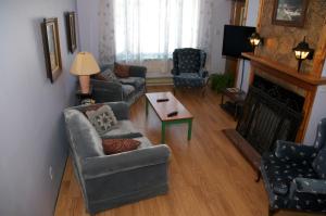 sala de estar con 2 sofás y chimenea en Bluenose Bed & Breakfast en Snow Lake