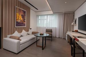 uma sala de estar com um sofá e uma mesa em THE MUMIAN HOTEL Shenzhen luohu em Shenzhen