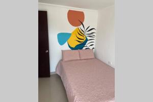 um quarto com uma cama com um quadro na parede em Apto en Getsemani el barrio mas cool de Cartagena em Cartagena de Indias