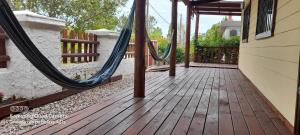 a porch with a hammock on a house at El Miyagi in Piriápolis