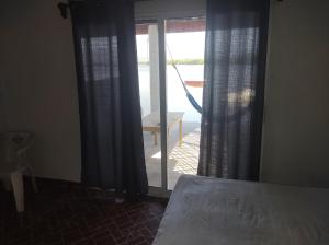 Schlafzimmer mit einem Bett und einer Glasschiebetür in der Unterkunft Club Cadena in Acapulco