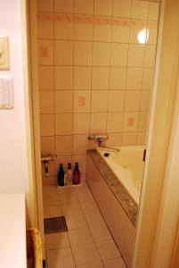 a bathroom with a tub and a tiled floor at Ena Hotel Venus in Ena