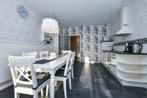 eine Küche mit einem weißen Tisch und weißen Stühlen in der Unterkunft Villa Hoffnung Wohnung 3 in Kellenhusen