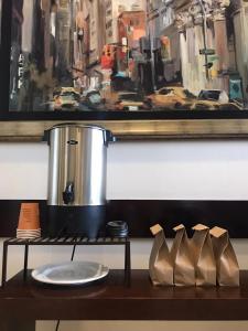 une table avec un pot, une plaque et un tableau dans l'établissement Hotel Plaza Chihuahua, à Chihuahua