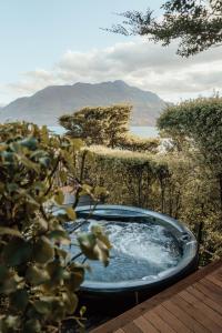 a hot tub sitting on a deck with a plant at Hotel St Moritz Queenstown - MGallery by Sofitel in Queenstown