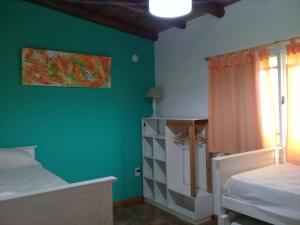 una camera da letto con pareti verdi, un letto e una finestra di La Solita a Chajarí
