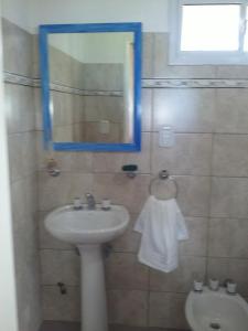 a bathroom with a sink and a mirror and a toilet at La Solita in Chajarí