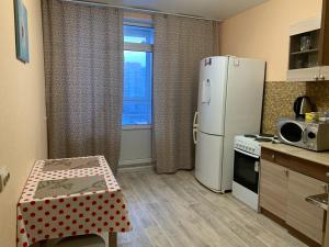 スルグトにあるУютная квартира на Захароваのキッチン(冷蔵庫、テーブル付)