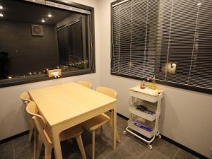 a dining room with a table and chairs and a window at Fukiagehama Field Hotel in Ichikikushikino