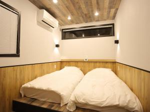 two beds in a room with a window at Fukiagehama Field Hotel in Ichikikushikino