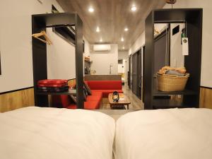 1 dormitorio con 1 cama y 1 sofá rojo en Fukiagehama Field Hotel en Ichikikushikino