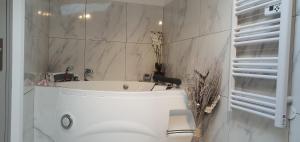 uma casa de banho com uma banheira branca e um lavatório. em Love Rooms de la Presqu'île em Saint-Vincent-de-Paul
