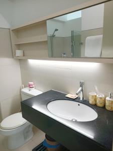 um banheiro com uma pia, um vaso sanitário e um espelho em Citihouse Ho Chi Minh Apartment em Cidade de Ho Chi Minh