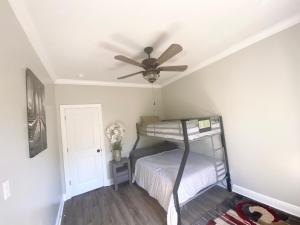 a bedroom with a bunk bed with a ceiling fan at Bungalow Beach house 100 yards from the beach in Bay Saint Louis