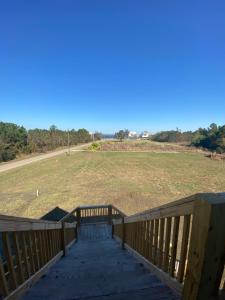 a wooden deck with a view of a field at Bungalow Beach house 100 yards from the beach in Bay Saint Louis