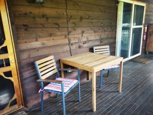 - une table en bois et 2 chaises sur une terrasse couverte dans l'établissement Peaceful cabin in a rural setting 2km from CBD, à Tamworth
