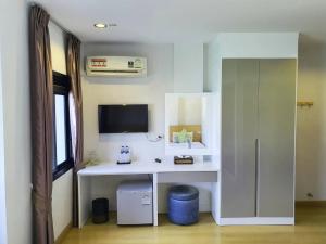 a room with a white desk with a tv on the wall at Klongrien Boutique Hotel in Hat Yai