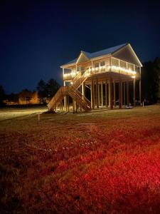 a large house with a staircase in a field at night at Bungalow Beach house 100 yards from the beach in Bay Saint Louis