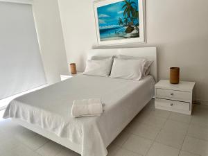 Un dormitorio blanco con una cama blanca y una foto en Apartamento Premier 5-Edificio Sea View, en San Andrés