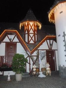 two teddy bears sitting outside of a house at night at Pousada dos Esquilos in Campos do Jordão