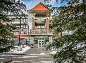 an apartment building with a balcony in the snow at Fenwick Vacation Rentals Suites with Pool & Hot tubs in Canmore