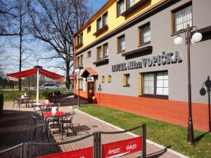 budynek ze stołami i krzesłami poza nim w obiekcie Hotel Milan Vopicka w mieście Hluboká nad Vltavou
