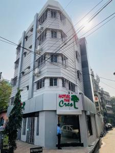 a person standing in front of a hotel in front of a building at Hotel The Crest in Kolkata