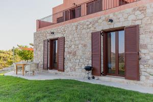 un edificio de piedra con una mesa y una mesa en Rhodes Retreat, en Kalithies