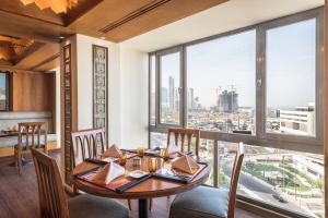 ein Esszimmer mit einem Tisch und Blick auf die Stadt in der Unterkunft Oasis Hotel in Kuwait