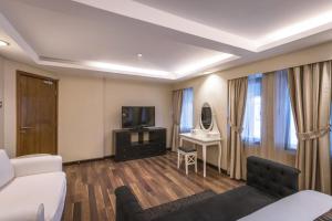 a hotel room with a bed and a tv and a couch at Oasis Hotel in Kuwait