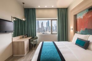 a hotel room with a bed and a desk and a window at Oasis Hotel in Kuwait