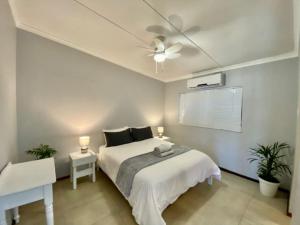 Surf Motel في أومدلوتي: غرفة نوم بسرير ومروحة سقف