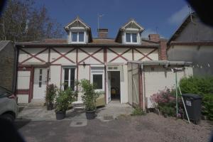 a white house with two windows and a garage at Good luc 150 m de la mer centre ville parking gratuit in Luc-sur-Mer