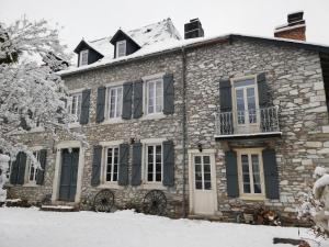 una casa de piedra con nieve encima en Le domaine des 3 marmottes Chambres d' hôtes, en Cierp