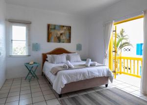 a bedroom with a large bed and a balcony at Santorini Thira 38 - Family Only in Ballito