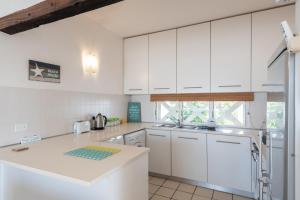 eine Küche mit weißen Schränken und einer Arbeitsplatte in der Unterkunft Santorini Thira 38 - Family Only in Ballito