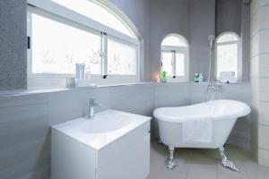 een witte badkamer met een wastafel en een bad bij 林居民宿 in Jinhu