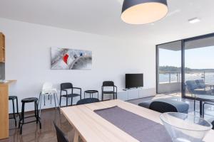 a living room with a table and chairs and a tv at Vizula Sunset F - Noa & Aurelia Maris in Medulin