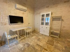 a room with a television and a table and chairs at AD HOUSE - Living Room in Castellana Grotte