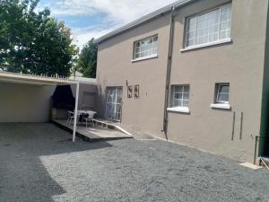 a building with a garage and a table in front of it at Crane Cottage in Colesberg