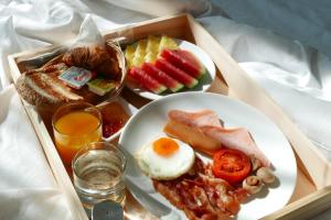 a tray of breakfast food with eggs toast and fruit at Le Tada Residence in Bangkok