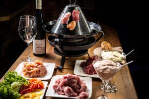uma mesa coberta com pratos de comida e taças de vinho em Mountainlovers Berghotel SeidlAlm em Saalbach-Hinterglemm