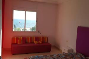 Azurh في الحمامات: غرفة معيشة مع أريكة حمراء ونافذة