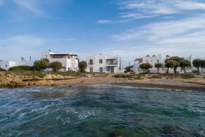 a body of water with houses in the background at Milos Waves Luxury Apartments in Pollonia