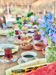 a wooden table topped with plates and bowls of food at Alaçatı Barbarossa Hotel in Cesme