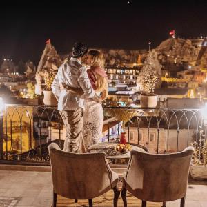 a couple kissing on a balcony at night at Caftan Cave Suites in Goreme