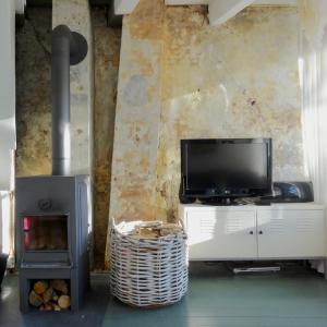 a living room with a tv and a stove at Choco Loca Loft, Bed, Bad & Bol in Den Bosch
